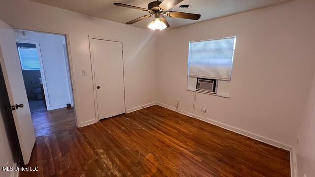 unfurnished bedroom with dark wood finished floors, a ceiling fan, and baseboards