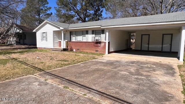 ranch-style house featuring crawl space, an attached carport, driveway, and brick siding