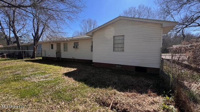 rear view of property featuring crawl space, a yard, and fence