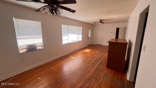 spare room with wood finished floors, baseboards, and ceiling fan