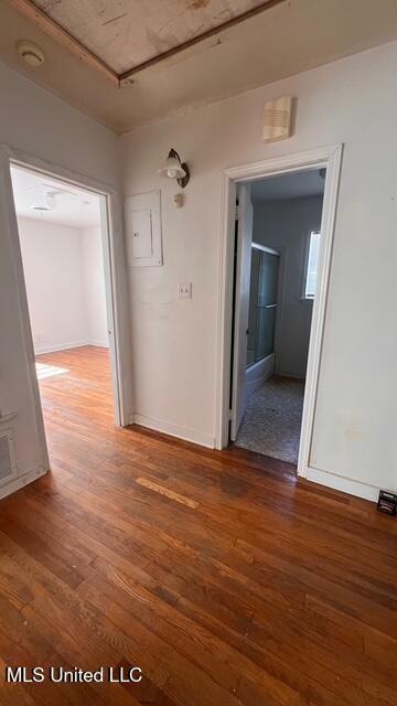 hall with light wood finished floors, visible vents, and baseboards