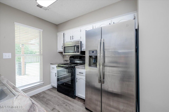 6967 Green Way Cv, Olive Branch, MS 38654 - kitchen with appliances with stainless steel finishes, white cabinetry, light wood-style floors, light countertops, and a textured ceiling