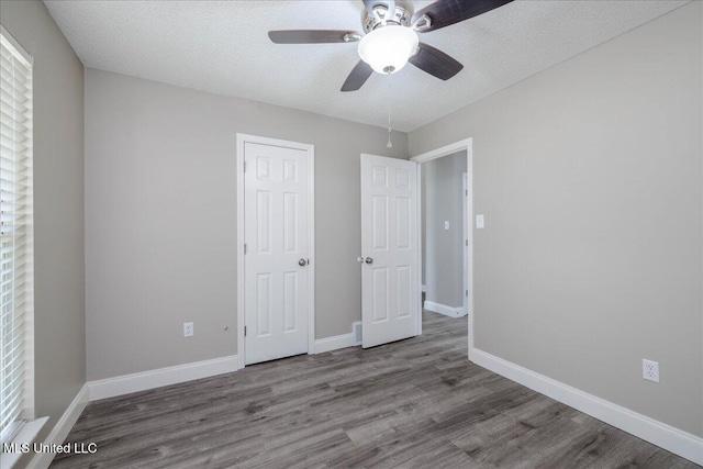 6967 Green Way Cv, Olive Branch, MS 38654 - unfurnished bedroom featuring wood finished floors, a ceiling fan, and a textured ceiling