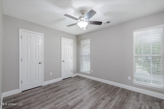 6967 Green Way Cv, Olive Branch, MS 38654 - unfurnished bedroom featuring wood finished floors, a textured ceiling, and ceiling fan