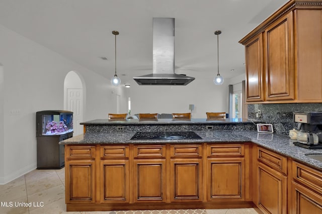 kitchen featuring decorative light fixtures, island exhaust hood, dark stone counters, and black cooktop