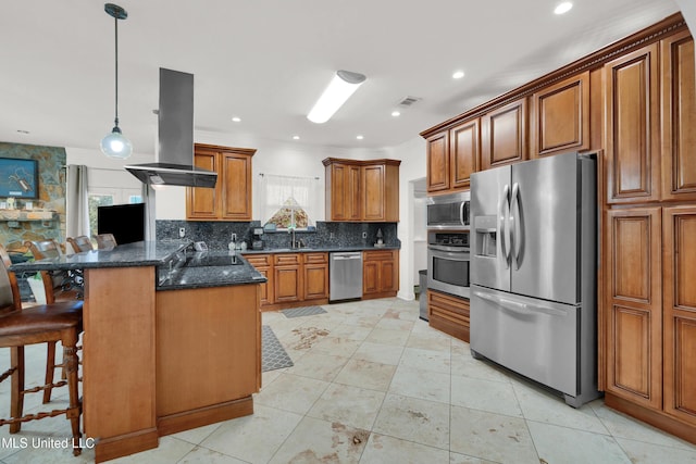 kitchen with hanging light fixtures, a kitchen breakfast bar, decorative backsplash, island range hood, and appliances with stainless steel finishes