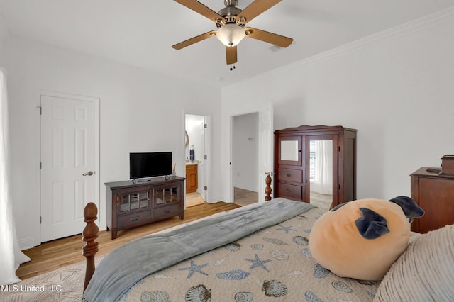 bedroom with ensuite bathroom, light hardwood / wood-style flooring, ceiling fan, and ornamental molding