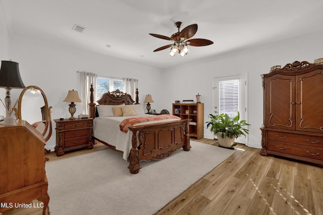 bedroom with light hardwood / wood-style flooring, multiple windows, ornamental molding, and ceiling fan