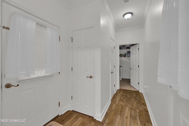 hall with light wood-type flooring and ornamental molding