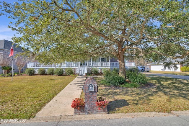 view of property hidden behind natural elements featuring covered porch and a front yard