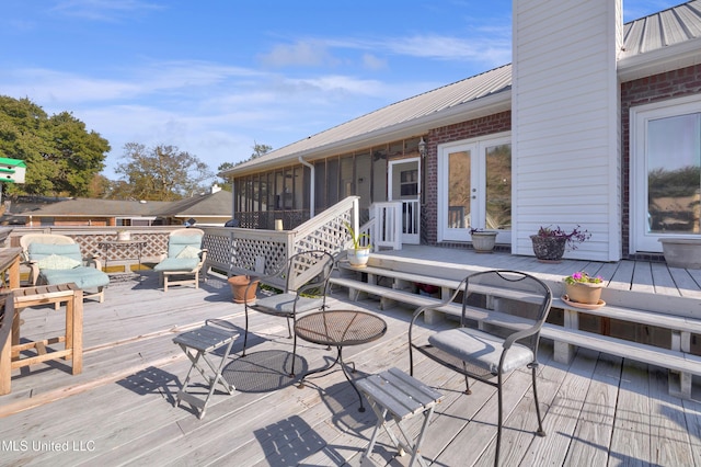 wooden terrace featuring french doors and a sunroom