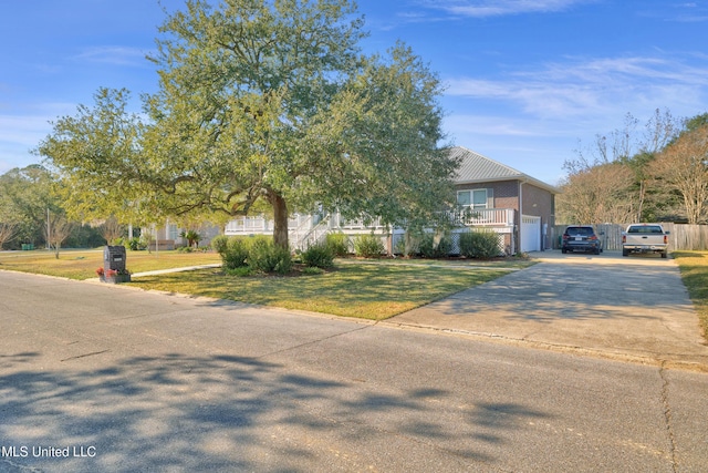 obstructed view of property featuring a garage and a front lawn