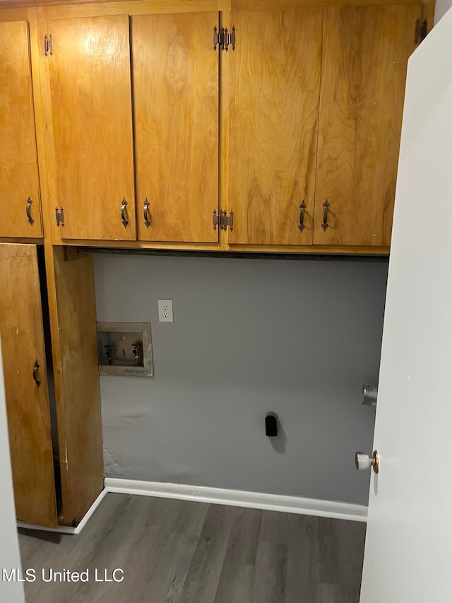 clothes washing area with cabinets, dark hardwood / wood-style floors, and washer hookup