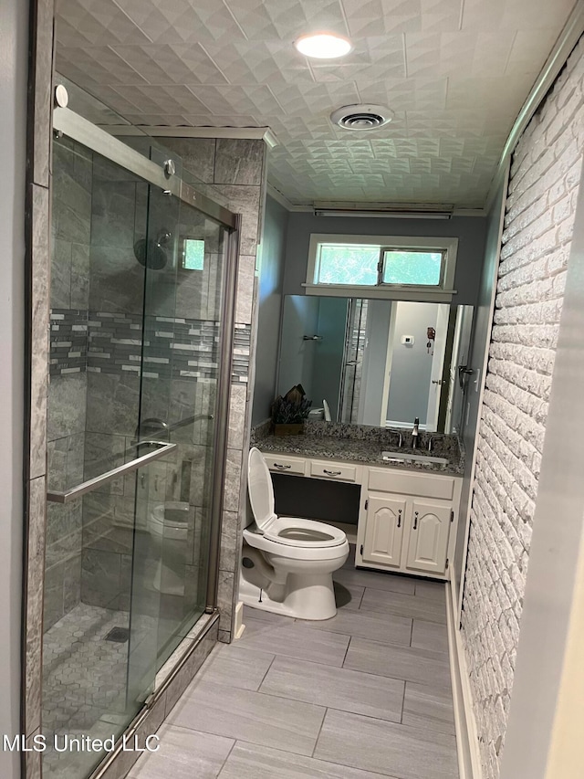 bathroom with vanity, toilet, and a shower with door