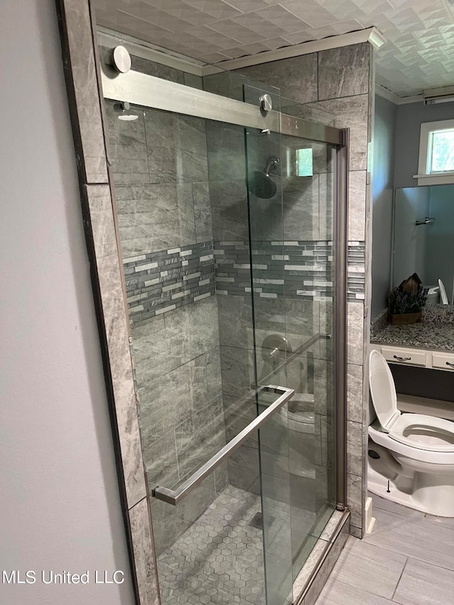 bathroom with a shower with door and toilet