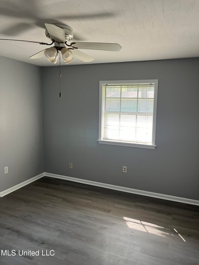 unfurnished room featuring dark wood-type flooring, a textured ceiling, and ceiling fan