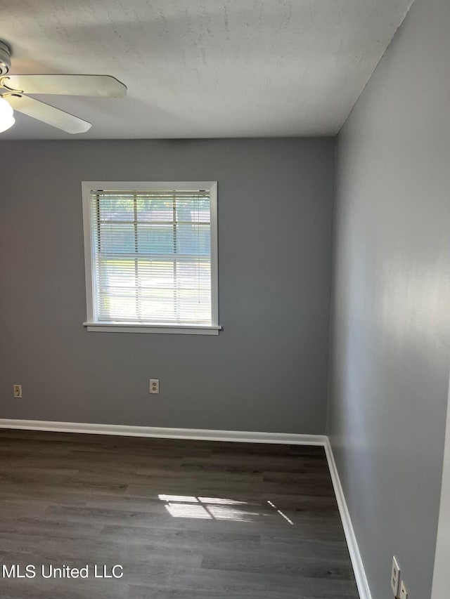 unfurnished room with dark hardwood / wood-style floors and ceiling fan