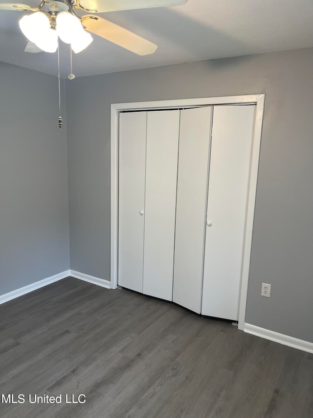 unfurnished bedroom featuring dark hardwood / wood-style flooring, a closet, and ceiling fan