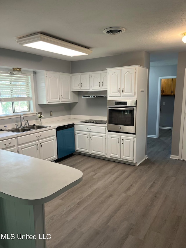 kitchen featuring stainless steel oven, dishwashing machine, and white cabinets