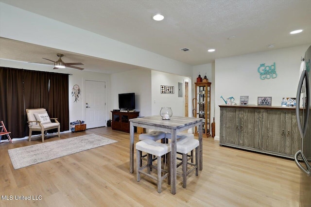 dining area with light wood-type flooring, visible vents, a textured ceiling, and recessed lighting