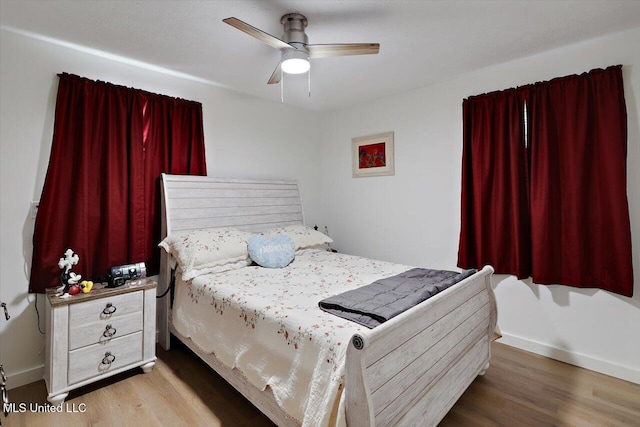 bedroom featuring ceiling fan, baseboards, and wood finished floors