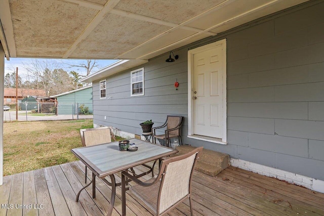 deck featuring fence, outdoor dining area, and a yard