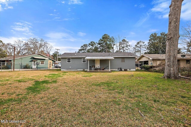 rear view of property featuring a patio area, a lawn, and fence