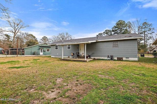 rear view of house with crawl space, fence, a patio, and a yard