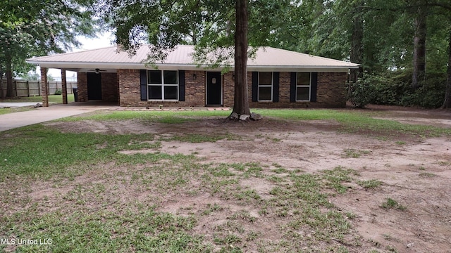 ranch-style home featuring brick siding, concrete driveway, fence, metal roof, and an attached carport