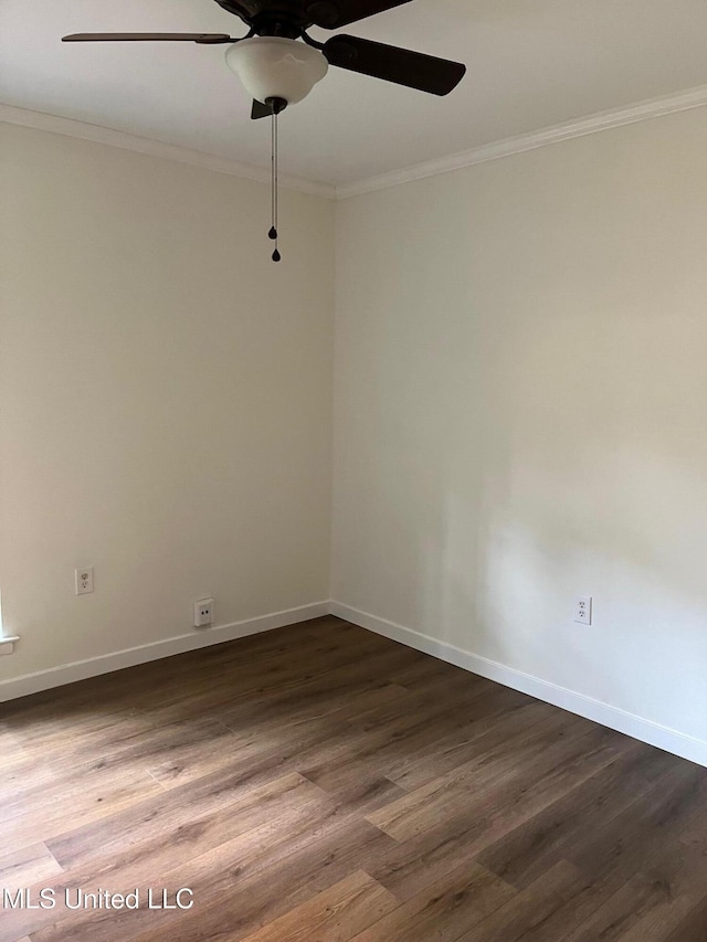 spare room with ornamental molding, dark wood finished floors, a ceiling fan, and baseboards