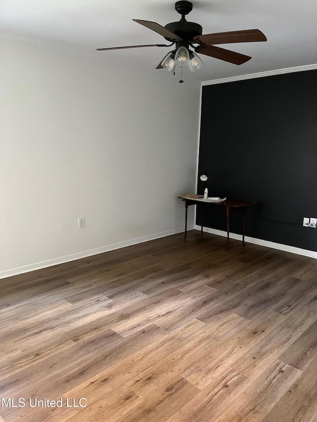 spare room with ceiling fan, crown molding, baseboards, and wood finished floors