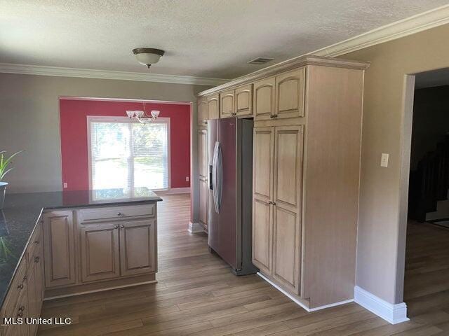 kitchen featuring ornamental molding, a notable chandelier, stainless steel refrigerator with ice dispenser, and wood-type flooring