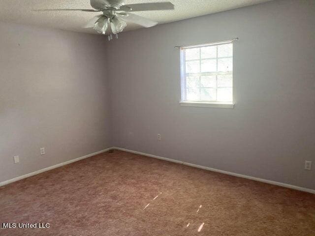 unfurnished room with a textured ceiling, carpet flooring, and ceiling fan