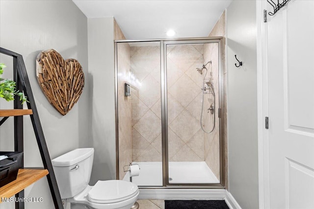 bathroom with a shower with door, toilet, and tile patterned floors