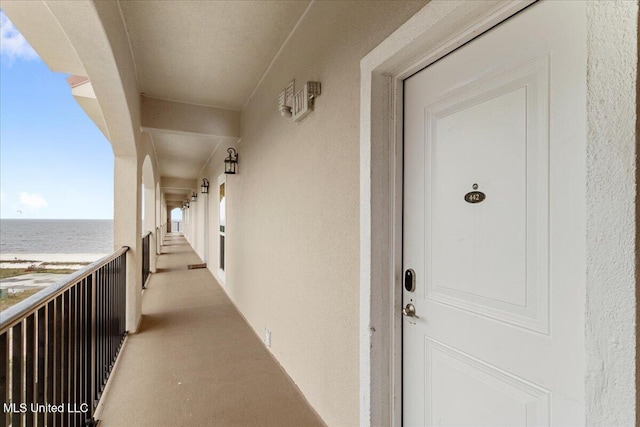 entrance to property with a water view and a balcony