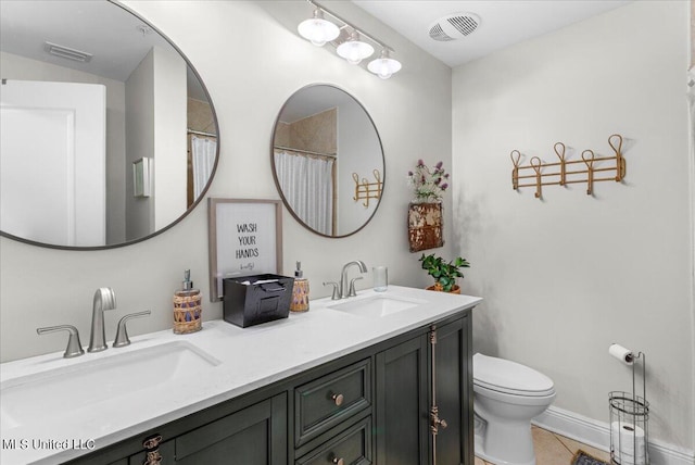 bathroom featuring vanity, toilet, and tile patterned floors