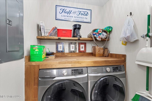 clothes washing area with washing machine and dryer and electric panel