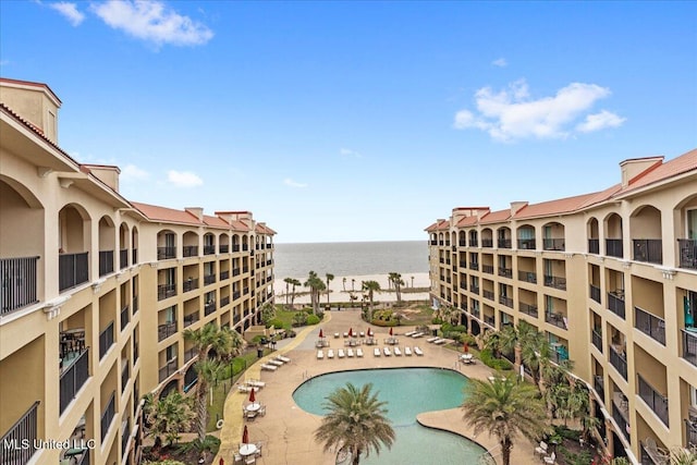 view of pool with a patio area and a water view