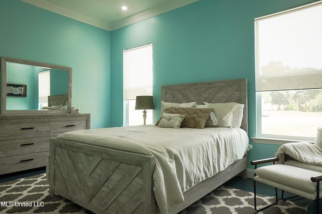 bedroom with ornamental molding and wood finished floors