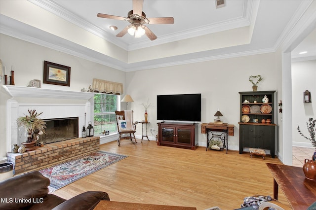 7622 Fairway Dr, Diamondhead, MS 39525 - living area with a ceiling fan, light wood-type flooring, a raised ceiling, ornamental molding, and a fireplace