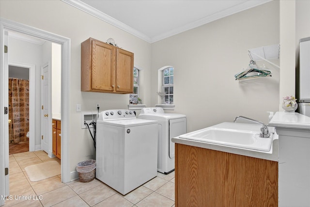 7622 Fairway Dr, Diamondhead, MS 39525 - laundry room with washing machine and clothes dryer, crown molding, cabinet space, and light tile patterned floors