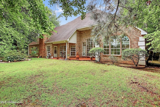 7622 Fairway Dr, Diamondhead, MS 39525 - rear view of house featuring a lawn, a chimney, brick siding, and roof with shingles