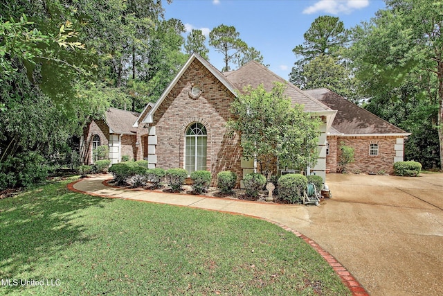 7622 Fairway Dr, Diamondhead, MS 39525 - view of front of house featuring brick siding, a front yard, concrete driveway, and roof with shingles