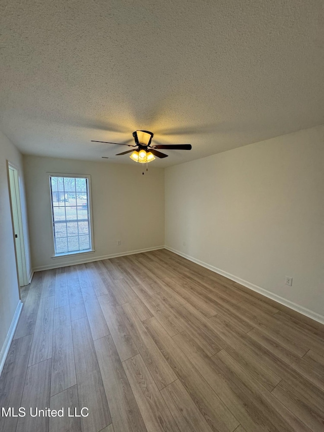 spare room featuring ceiling fan, a textured ceiling, and light wood-type flooring