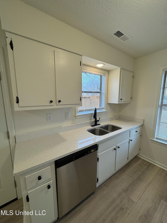 kitchen with dishwasher, sink, and white cabinets