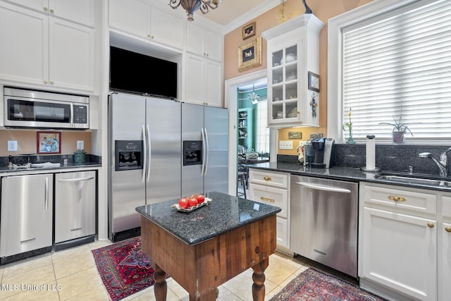1616 Poplar Blvd, Jackson, MS 39202 - kitchen with appliances with stainless steel finishes, a sink, light tile patterned flooring, white cabinetry, and glass insert cabinets