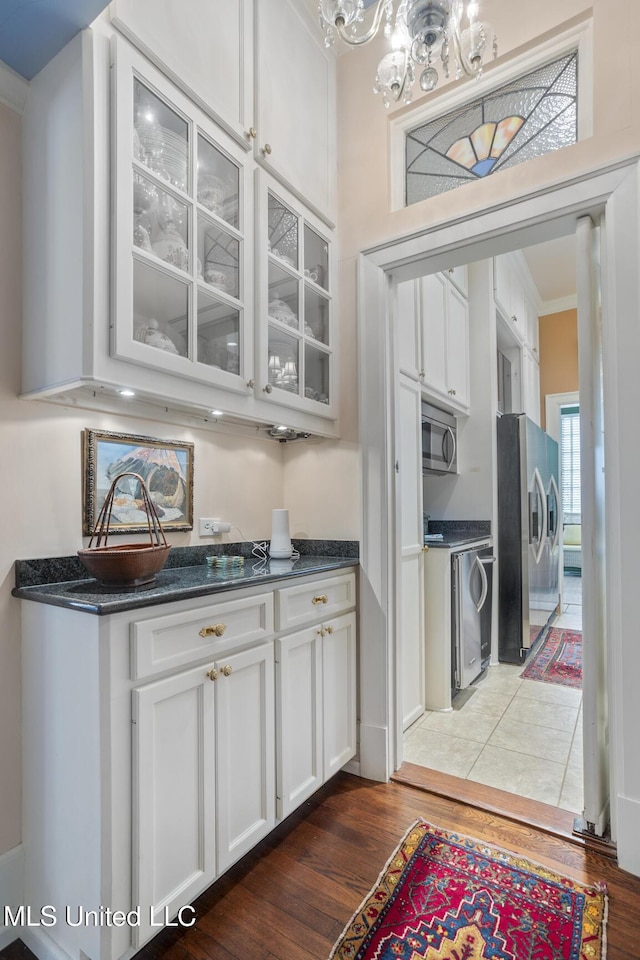 1616 Poplar Blvd, Jackson, MS 39202 - bar with stainless steel appliances, wood finished floors, a chandelier, crown molding, and washer / dryer