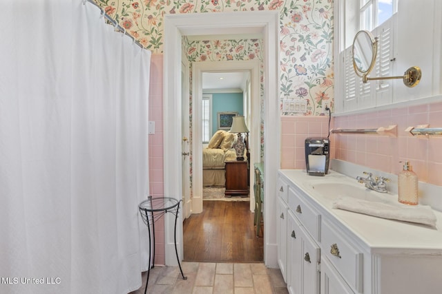 1616 Poplar Blvd, Jackson, MS 39202 - ensuite bathroom featuring wallpapered walls, plenty of natural light, vanity, and tile walls