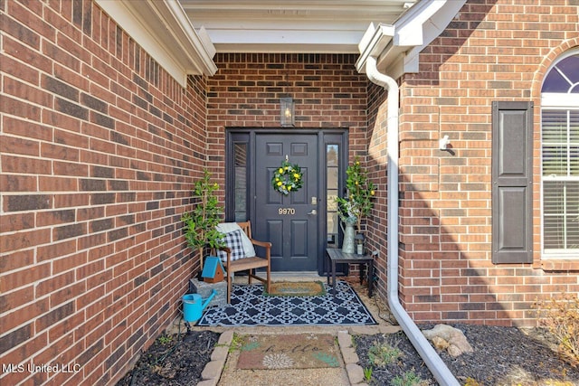 entrance to property featuring brick siding