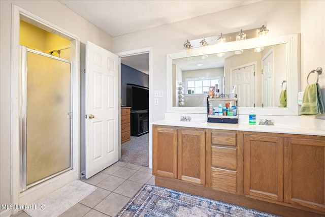 full bath with double vanity, tile patterned flooring, a shower stall, and a sink